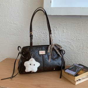 Detail of dark brown retro shoulder bag with cat embossing and plush star charm