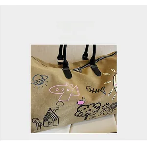 Close-up of khaki canvas travel bag with playful black and pink graffiti illustrations