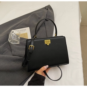 Chic black leather handbag styled with grey blazer and gold twist-lock detail