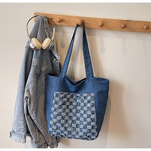Détail du sac cabas en jean bleu avec poches à carreaux vieillies et larges bandoulières