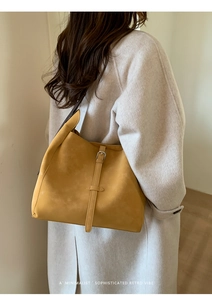 Vue latérale du sac hobo jaune mat avec détail de sangle en cuir et boucle en métal