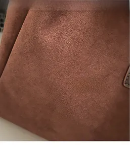 Detailed macro view of the premium brown matte suede fabric with soft texture