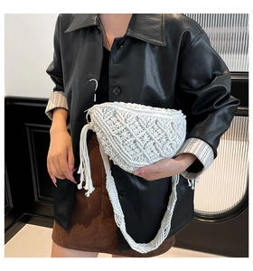 Detail of bohemian white hand-woven crossbody bag with fringe tassels and vintage crochet pattern