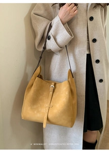 Sac hobo rétro jaune avec bandoulière réglable porté avec un manteau beige