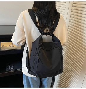 Detailed back view of a black high-density nylon tote bag worn on a model's back