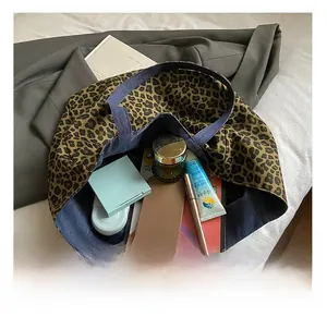 Detail of spacious leopard print canvas tote bag with denim blue lining and pocket storage
