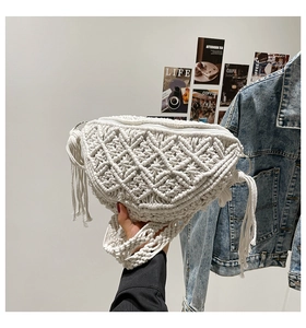 Detail of white macrame crescent bag showing intricate woven texture and tassels