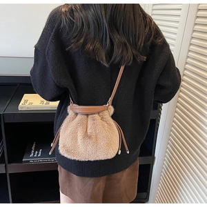 Detailed texture of brown faux fur bucket bag with slim leather strap and drawstring