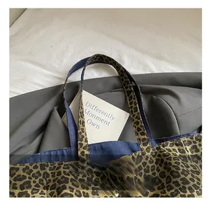 Detail showing leopard print canvas tote bag with sturdy dark blue denim handles