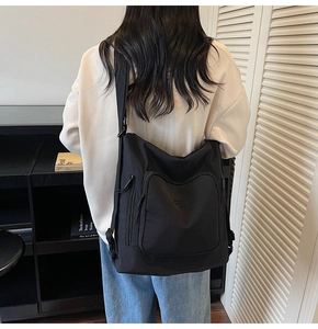 Detail of a black nylon multifunctional backpack with multiple zipper pockets for daily use