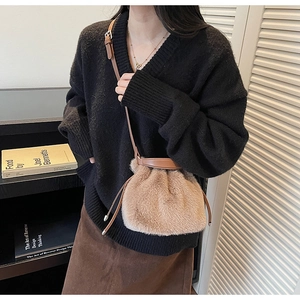 Detailed side view of light brown plush bucket bag worn by model in a stylish interior