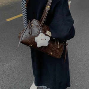 Detail of dark brown embossed shoulder bag with Bread Cat pattern and star plush charm