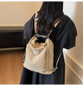 Rear view of khaki nylon backpack on model, showing large capacity and zipper details
