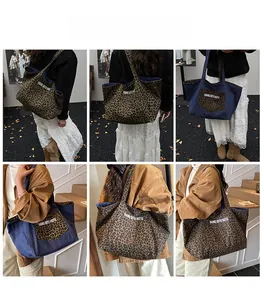 Detail view of double-sided tote bag featuring leopard print and denim with shoulder strap