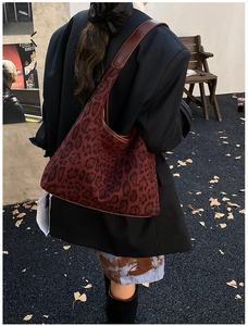 Detailed street-style view of vintage leopard print hobo bag in deep red and brown