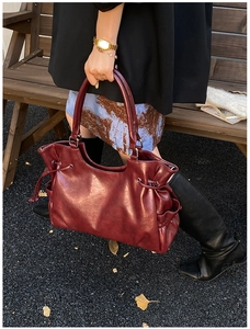 Detail of vintage burgundy tote bag showing oil wax leather texture and drawstring design