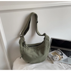 Détail du sac demi-lune en toile vert armée avec bandoulière réglable et fermeture éclair