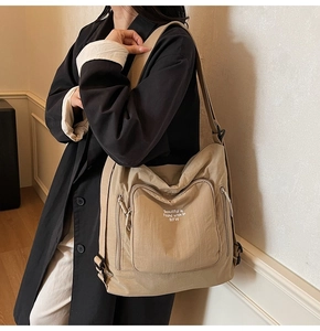 Detail of khaki nylon tote bag with white BIFW art text and adjustable wide strap