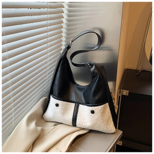 Detail of bicolour tote bag featuring black faux leather and white plush fleece texture