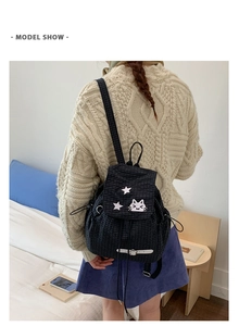Detailed shot of black and white plaid backpack with star and cat embroidery patches