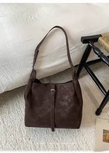 Vue détaillée du sac cabas rétro marron foncé avec texture mate sur tapis moelleux