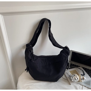 Détail du sac hobo en toile noire avec bandoulière réglable et fermeture éclair