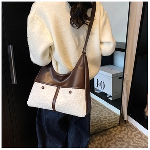 Detail of plush faux shearling and brown leather tote bag with stylish buckles