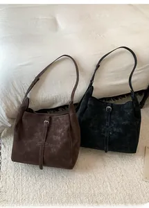 Vue détaillée de grands sacs cabas noir et marron avec boucles au style rétro