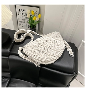 Detail of bohemian woven crescent bag with diamond geometric patterns and long tassels