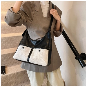 Detail view of large faux shearling tote bag with leather pockets on stairs