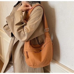 Détail du sac bandoulière en toile caramel avec sangle réglable et boucle en métal