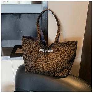 Detail of canvas leopard print tote bag featuring HQTU lettering and spacious interior