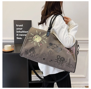 Detail of graffiti canvas travel bag showing large capacity and adjustable strap on model