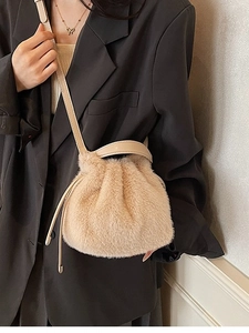 Fashionable beige plush drawstring bucket bag with leather strap and soft fur texture