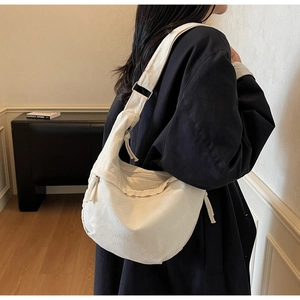 Détail d'un sac en toile beige montrant sa grande capacité et son design minimaliste