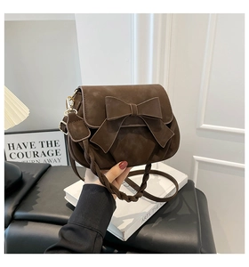 Detail of dark brown matte PU shoulder bag featuring a large bow and braided strap