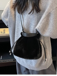 Fashionable black faux fur bucket bag with drawstring closure and leather shoulder strap