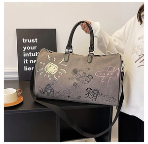 Detail view of large grey travel bag with black graffiti prints and sturdy nylon handles