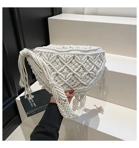 Detail of white macrame chest bag featuring handmade woven texture and long side tassels