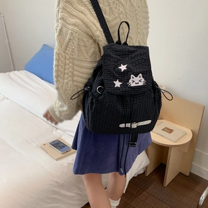 Close-up of black plaid drawstring backpack with cute cat embroidery and white leather buckles