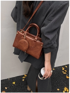 Detail of dark brown vintage square handbag with detachable mini coin purse and strap