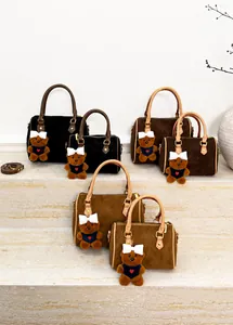Détail des sacs Boston en plusieurs tailles et couleurs avec breloques d'ours décoratifs