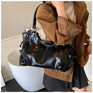 Detail of black glossy faux leather tote bag with drawstring side pockets and sleek finish