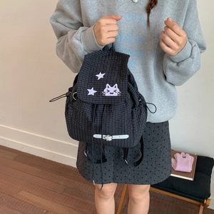 Close-up of black plaid drawstring backpack with cat embroidery and star patch details