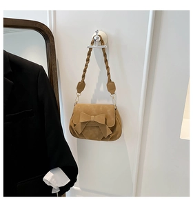Dettaglio borsa sottobraccio in camoscio kaki con grande fiocco e tracolla intrecciata