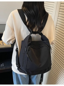 Versatile black nylon backpack with wide straps and large front zip pocket for students