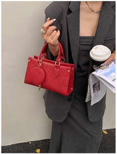 Detail of red leather square handbag with mini round coin purse and gold hardware