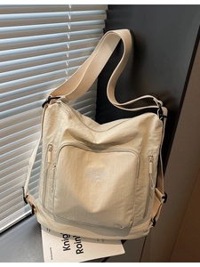 Versatile cream large capacity tote bag with adjustable straps and embroidery detail