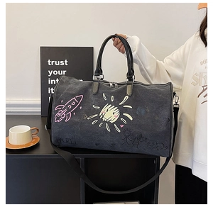 Detail of grey canvas travel bag with colorful hand-drawn graffiti and adjustable straps
