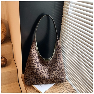 Macro shot of vintage leopard print hobo tote bag with green leather trim details